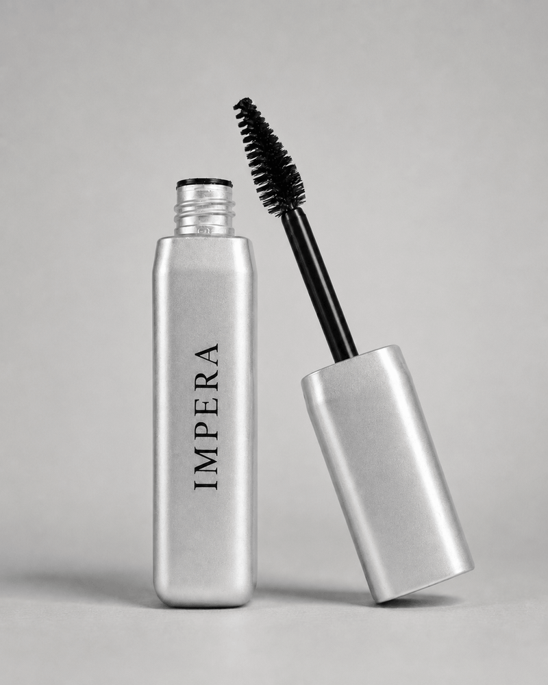 Silver volumizing mascara bottle with black wand on a gray background, featuring the brand 'IMPERA'.